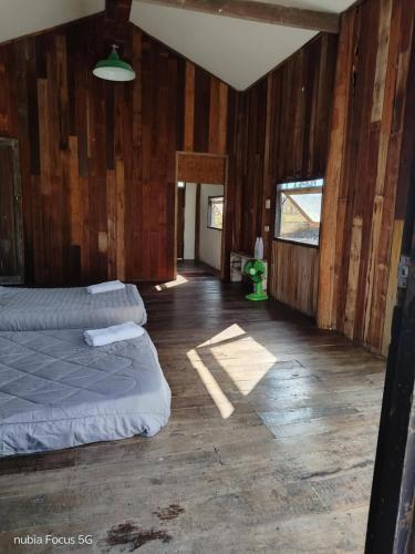 a bedroom with two beds in a room with wooden walls at Bannuea Local Life in Ban Nam Lat
