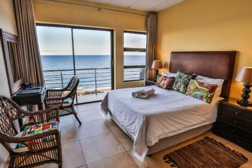 a bedroom with a bed with a view of the ocean at Zimbali View Eco Guesthouse in Ballito