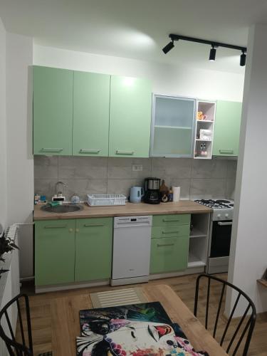 una cucina con mobili verdi e un tavolo di legno di A small paradise a Skopje