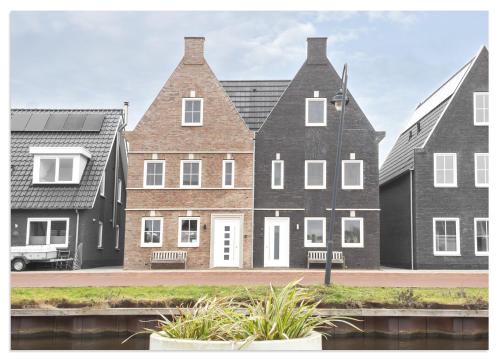 a large brick house with white doors and windows at Waterluxe Villa in Stavoren in Stavoren