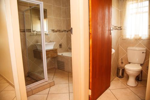 a bathroom with a toilet and a shower and a sink at Blyde Canyon, A Forever Resort in Matibidi