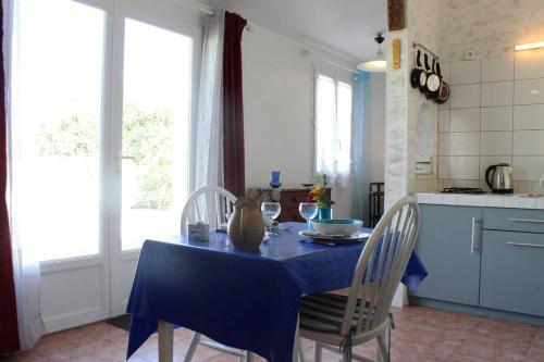 d'une cuisine avec une table et des chaises bleues. dans l'établissement Maison 2 pièces 2 couchages Dolus d'Oléron DDO000-022, à Dolus-d'Oléron