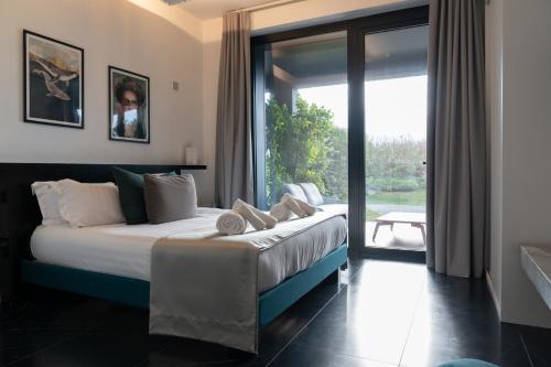 a bedroom with a bed and a large window at Secret Garden Resort & Spa in Palma Campania