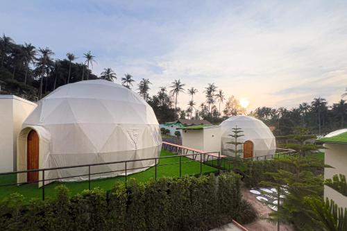 two domed domes in a yard next to a building at Sunny Side Resort Koh Tao in Koh Tao