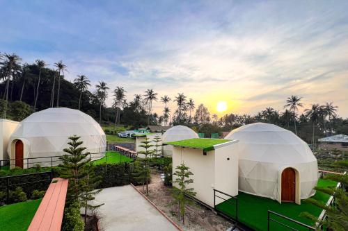 a group of domes with the sunset in the background at Sunny Side Resort Koh Tao in Koh Tao