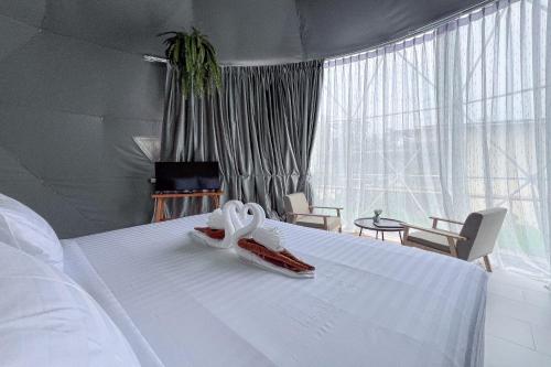 a bedroom with a white bed with a pair of shoes on it at Sunny Side Resort Koh Tao in Koh Tao