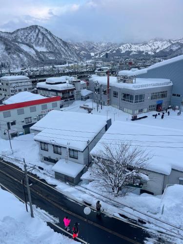 a city covered in snow with mountains in the background at Hotel K Yuzawa 越後湯澤溫泉旅館 in Yuzawa