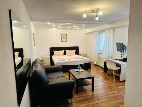 a living room with a bed and a couch at Hotel Hofmann Zur Mühle in Bad Krozingen