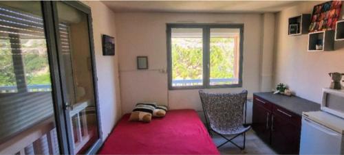 Cette chambre comprend un lit, une chaise et une fenêtre. dans l'établissement Charmant studio climatisé au milieu du parc naturel, à Marseille