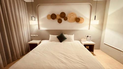 a bedroom with a bed with hats on the wall at 禾夏民宿Her Shot Inn in Hengchun