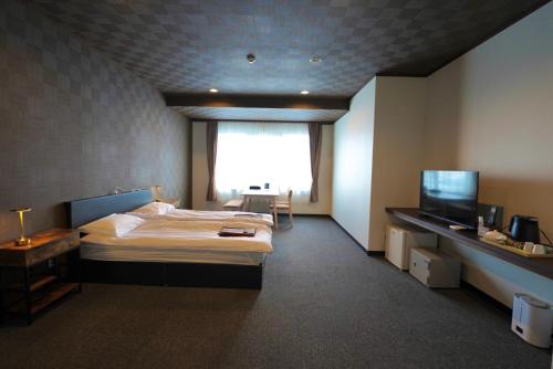a hotel room with a bed and a television at Hotel K Yuzawa 越後湯澤溫泉旅館 in Yuzawa