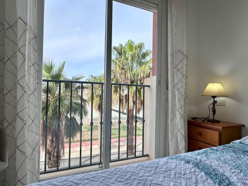 a bedroom with a large window with a view of the beach at Apartamento Playa Calahonda El Farillo con terraza in Calahonda