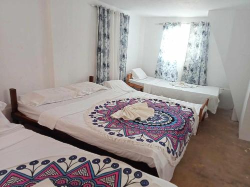 a room with three beds and a window at Isla Haruhay in Dapa