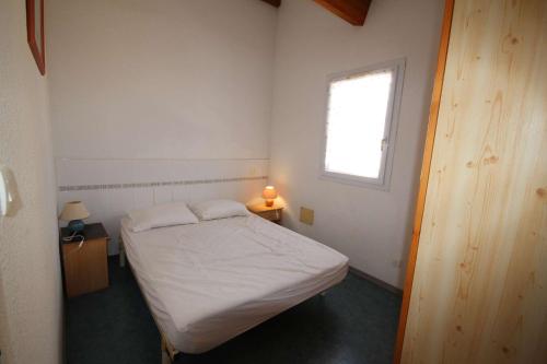une petite chambre avec un lit et une fenêtre dans l'établissement Villa d'angle pour 6 personnes, 3 chambres à l'étage, résidence LES MARINES avec piscine commune, 200m de la mer à Portiragnes plage LRMA65B, à Portiragnes