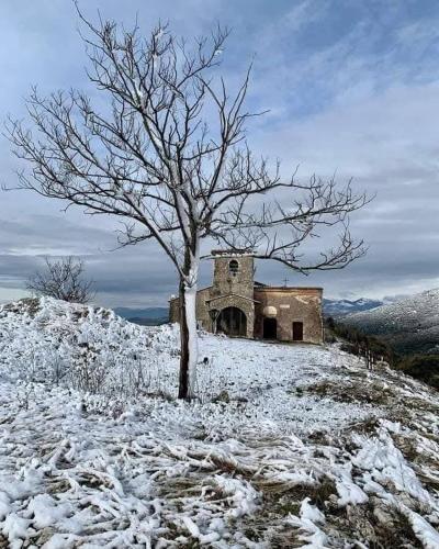 an old building on a snow covered hill with a tree at Villa Anna! in Castrocielo