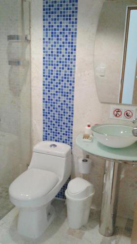 a bathroom with a white toilet and a sink at Vista Marina Residence in Boca Chica