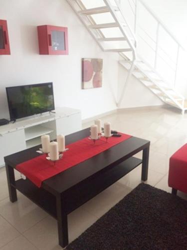 a living room with a table with candles and a tv at Vista Marina Residence in Boca Chica
