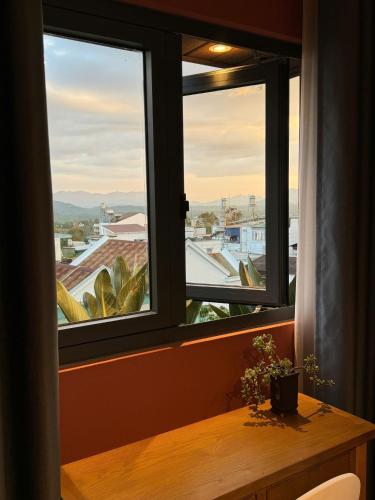 a window with a table and a view of a city at Lanh's Homestay Bảo Lộc in Bao Loc