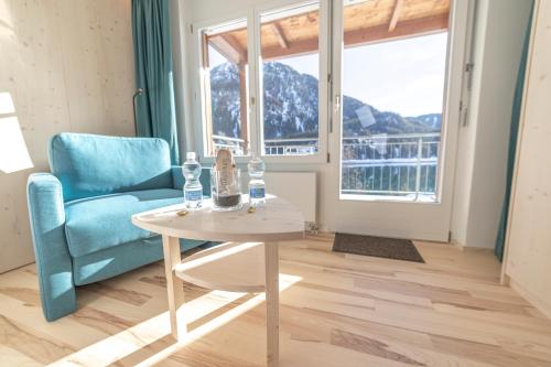 a living room with a table and a chair and a window at Hotel Seebüel in Davos
