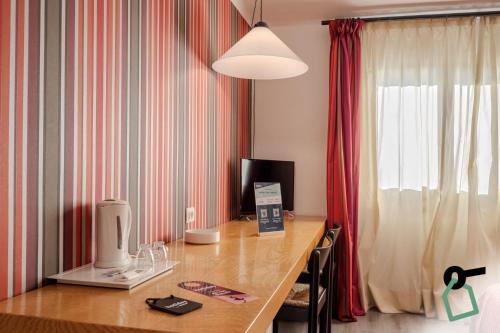 a room with a desk with a computer and a window at HOTIDAY Room Collection - Sarzana in Sarzana