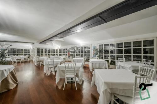 a dining room with white tables and chairs at HOTIDAY Room Collection - Sarzana in Sarzana