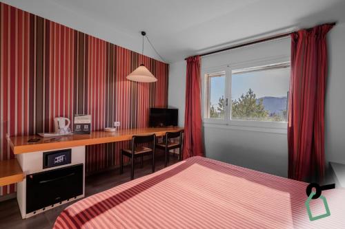 a hotel room with a desk and a bed at HOTIDAY Room Collection - Sarzana in Sarzana