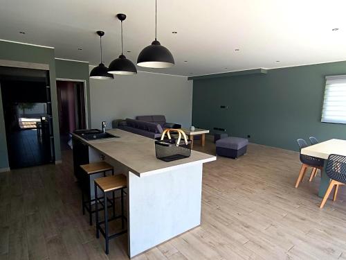 une cuisine et un salon avec un comptoir et des chaises dans l'établissement Villa Moderne avec Piscine proche Narbonne, à Sallèles-dʼAude