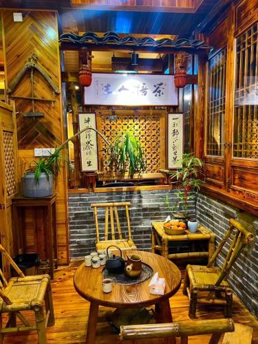 a room with a table and chairs and a wall with a window at 龙脊梯田一棵树友缘阁民宿 in Longsheng