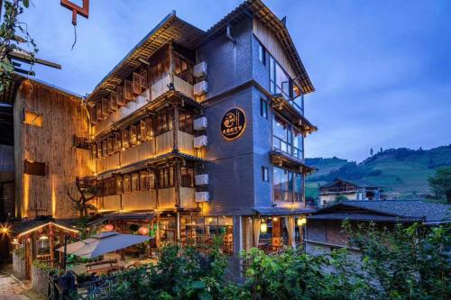 a large building with a restaurant in front of it at 龙脊梯田一棵树友缘阁民宿 in Longsheng