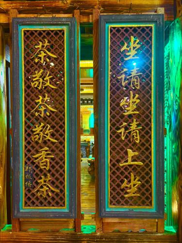 two glass doors with chinese writing on them at 龙脊梯田一棵树友缘阁民宿 in Longsheng