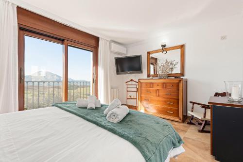 une chambre avec un grand lit avec des serviettes dessus dans l'établissement Villa Antequera, à Malaga