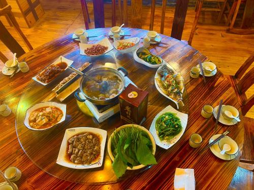 a wooden table with plates of food on it at 龙脊梯田一棵树友缘阁民宿 in Longsheng
