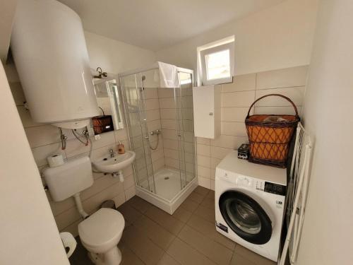 a bathroom with a washing machine and a washer at Green Village House in Ganna