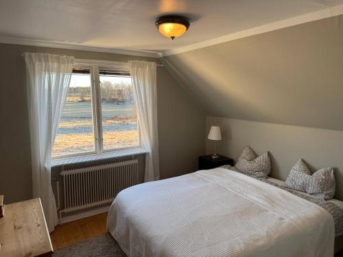 a bedroom with a white bed and a window at Hus Hornsö in Blomstermåla