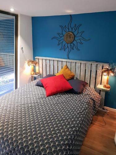 une chambre avec un grand lit avec un mur bleu dans l'établissement Grand T2 Ensoleillé 47m2 3 Etoiles, à La Grande Motte