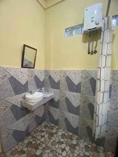 a bathroom with a sink and a mirror at Ridho's Homestay & Jungle Trekking in Bukit Lawang
