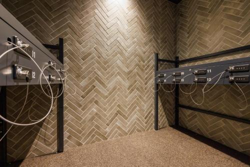 a bathroom with a tile wall with a shower at &Here TOKYO UENO in Tokyo
