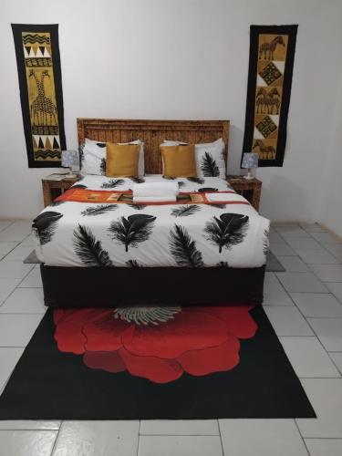 a bedroom with a bed with a bedspread with flowers at Sunshinevibe guest house in Kasane
