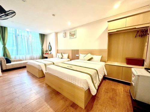 a hotel room with two beds and a couch at Royal Hotel Ha noi in Hanoi