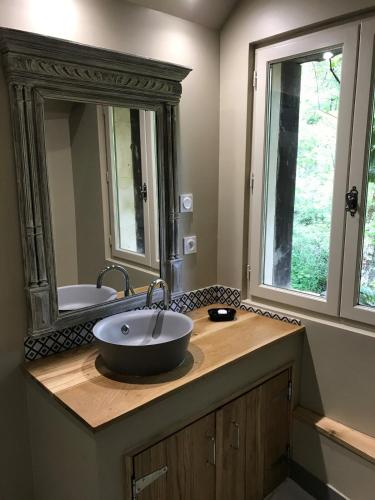 une salle de bain avec un lavabo et un grand miroir dans l'établissement Owi - Idyllisches Ferienhaus inmitten der Natur, à Payrac