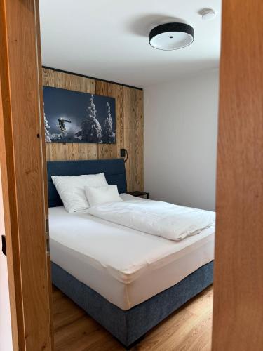 a bedroom with a bed with a wooden headboard at Chalet1500 Apartment Gerlitzen - Kärnten Card im Sommer inklusive! in Kanzelhöhe