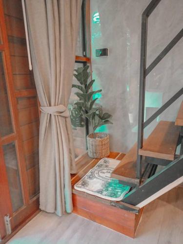 a window with a curtain and a potted plant at เรินนายหัว by KOYAD RESORT in Ban Wat Khao