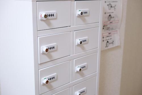 a white chest of drawers with dials on them at 鹿鳴館 in Yurihama