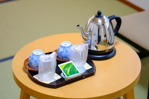 a tea set on a table with a tea pot at 鹿鳴館 in Yurihama