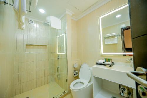 a bathroom with a toilet and a shower and a sink at Urban by CityBlue Hotel, Dar es Salaam in Dar es Salaam