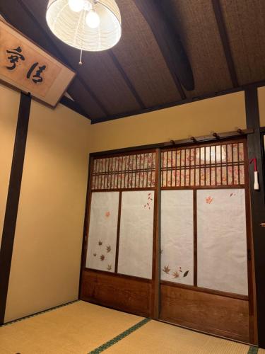 a room with a door with a window and a chandelier at 京町家-椿庵Kyomachiya-Tsubakian in Kyoto
