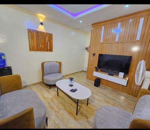 a living room with a tv and a table and chairs at Kiscourt apartment in Meran