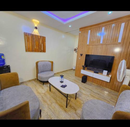 a living room with chairs and a table and a tv at Kiscourt apartment in Meran