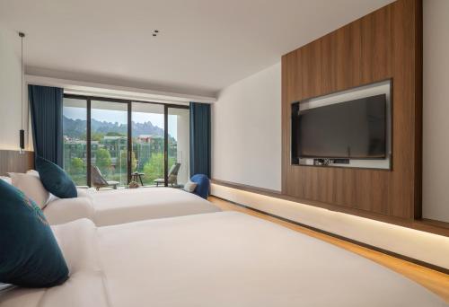 Postel nebo postele na pokoji v ubytování Zhangjiajie Happy Hotel