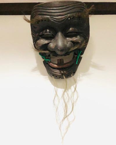 a mask hanging on a wall with hair on it at 京町家-椿庵Kyomachiya-Tsubakian in Kyoto